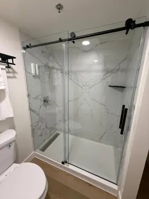 a bathroom with a glass shower with a toilet at MainStay Suites Victorville - Hesperia in Victorville