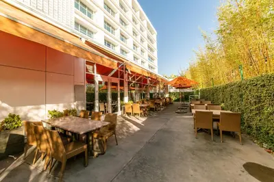 an outdoor patio with tables and chairs and a building at Miyako Hybrid Hotel Torrance in Torrance