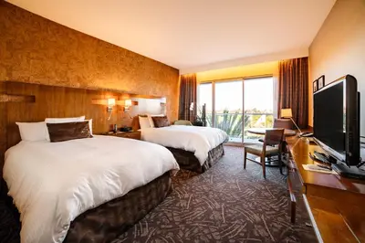 a hotel room with two beds and a flat screen tv at Miyako Hybrid Hotel Torrance in Torrance