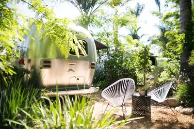 a couple of white chairs sitting in a garden at Caravan Outpost in Ojai
