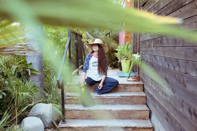 a woman in a hat sitting on the stairs at Caravan Outpost in Ojai