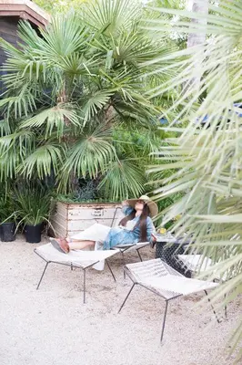 a man sitting on a bench with a hat on at Caravan Outpost in Ojai