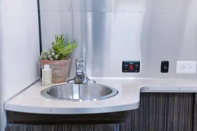 a bathroom sink with a faucet and a plant at Caravan Outpost in Ojai