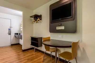 a dining room with a table and a tv on a wall at Motel 6-Redlands, CA in Redlands
