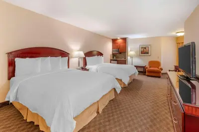 a hotel room with two beds and a flat screen tv at Best Western Plus West Covina Inn in West Covina