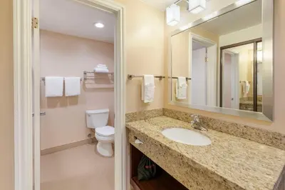 a bathroom with a sink and a toilet and a mirror at Best Western Plus West Covina Inn in West Covina