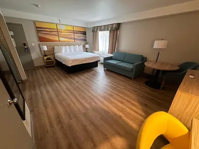 a hotel room with a bed and a couch at Days Inn & Suites by Wyndham Artesia in Artesia