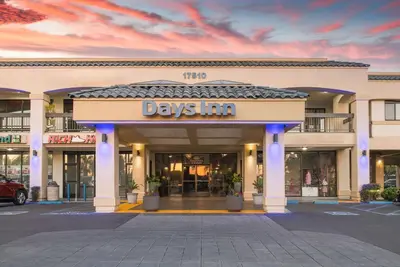 a day inn sign on the front of a building at Days Inn & Suites by Wyndham Artesia in Artesia