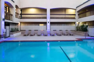 a swimming pool in a hotel with chairs and tables at Days Inn & Suites by Wyndham Artesia in Artesia