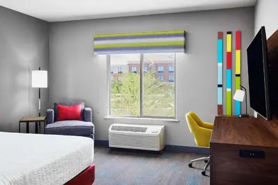 a bedroom with a bed and a window and a chair at Hampton Inn & Suites Ridgecrest in Ridgecrest