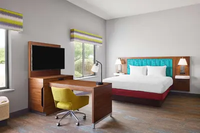a hotel room with a bed and a desk with a computer at Hampton Inn & Suites Ridgecrest in Ridgecrest