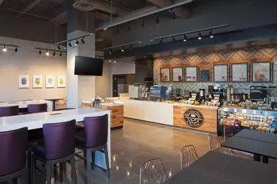 a restaurant with purple chairs and a counter at H Hotel Los Angeles, Curio Collection By Hilton in Los Angeles