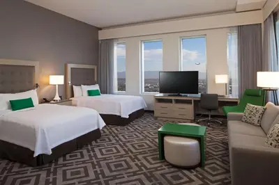 a hotel room with two beds and a flat screen tv at Homewood Suites By Hilton Los Angeles International Airport in Los Angeles