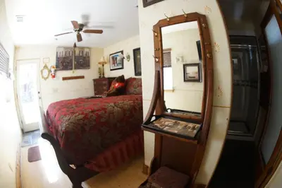 a bedroom with a bed and a mirror at FLEUR DE LAC EUROPERAN INn in Lake Arrowhead