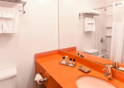 a bathroom with a sink and a mirror at The Tangerine - a Burbank Hotel in Burbank