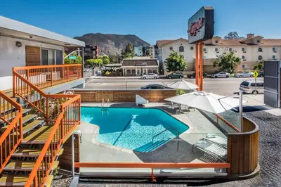 a swimming pool with orange railings next to a building at The Tangerine - a Burbank Hotel in Burbank