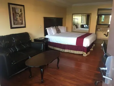 a hotel room with a bed and a couch at Budget Lodge San Bernardino in San Bernardino