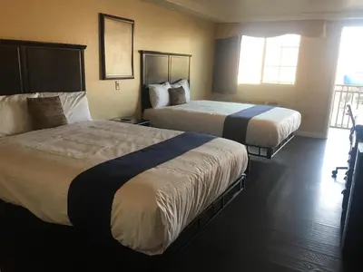 a hotel room with two beds and a window at Budget Lodge San Bernardino in San Bernardino