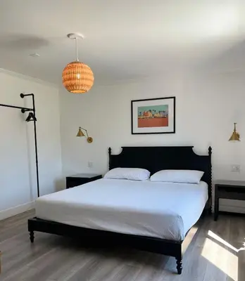 a bedroom with a bed and a pendant light at Anaheim Maingate Inn in Anaheim
