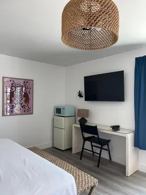 a bedroom with a bed and a desk and a television at Anaheim Maingate Inn in Anaheim