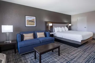 a hotel room with a bed and a blue couch at Hampton Inn & Suites Agoura Hills in Agoura Hills