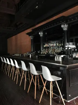 a bar with a row of white chairs in a room at Kawada Hotel in Los Angeles