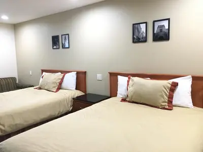 a hotel room with two beds and a couch at Simply Home Inn & Suites - Riverside in Riverside