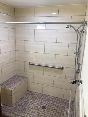 a shower stall with a bench in a bathroom at Simply Home Inn & Suites - Riverside in Riverside