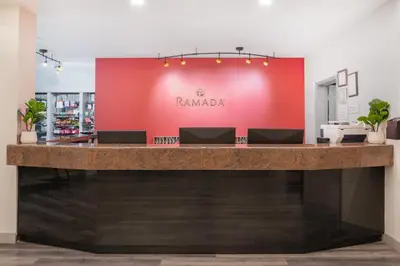 a bar in a store with a red wall at Ramada by Wyndham Bakersfield in Bakersfield