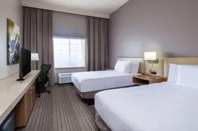a hotel room with two beds and a flat screen tv at Hilton Garden Inn Bakersfield in Bakersfield