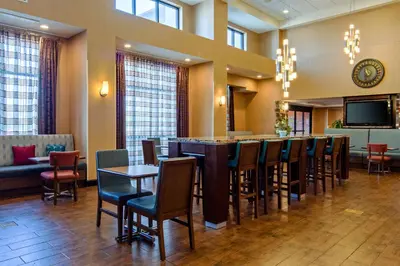 a restaurant with a bar with chairs and a tv at Hampton Inn and Suites Bakersfield / Highway 58 in Bakersfield