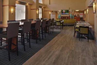 a dining room with tables and chairs in a restaurant at Hampton Inn and Suites Bakersfield North-Airport in Bakersfield
