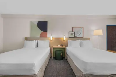a hotel room with two beds and a table at Spark by Hilton Bakersfield Central in Bakersfield