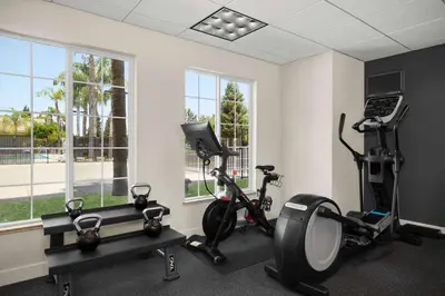 a gym with two treadmills and two exercise bikes at Homewood Suites Bakersfield in Bakersfield