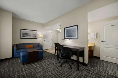 a hotel room with a couch and a desk and a bed at Homewood Suites Bakersfield in Bakersfield