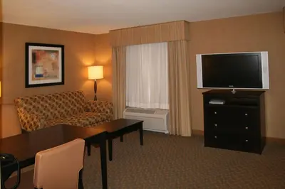 a hotel room with a couch and a television at Hampton Inn and Suites Barstow in Barstow