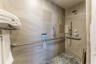 a shower stall in a bathroom with a shower curtain at Shade Hotel Redondo Beach in Redondo Beach