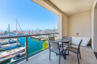 a balcony with a table and chairs and a view of a marina at Shade Hotel Redondo Beach in Redondo Beach