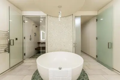 a bathroom with a white tub and a walk in shower at Shade Hotel Redondo Beach in Redondo Beach