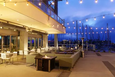 a restaurant with tables and chairs and lights at Shade Hotel Redondo Beach in Redondo Beach