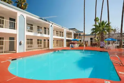 a large swimming pool in front of a building at Travelodge by Wyndham Bakersfield in Bakersfield