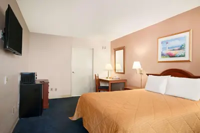 a hotel room with a bed and a flat screen tv at Travelodge by Wyndham Bakersfield in Bakersfield
