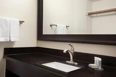 a bathroom with a sink and a mirror at Travelodge by Wyndham Bakersfield in Bakersfield
