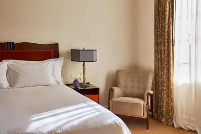a bedroom with a bed and a chair next to a window at Chateau Marmont in Los Angeles