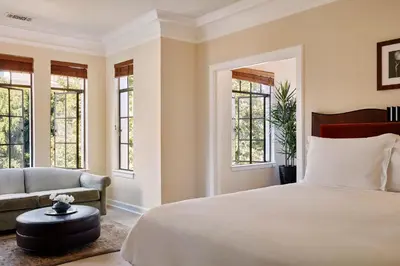 a bedroom with a bed and a couch and windows at Chateau Marmont in Los Angeles