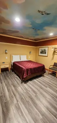 a bedroom with a bed with a red bedspread at Geneva Motel in Inglewood