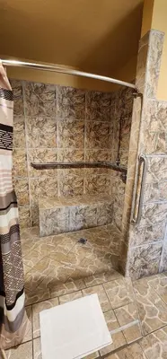 a bathroom with a shower with a stone wall at Geneva Motel in Inglewood
