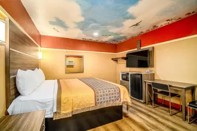 a hotel room with a bed and a tv at Geneva Motel in Inglewood