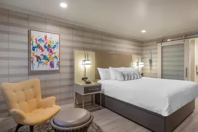 a bedroom with a large bed and a chair at Bluestem Hotel Torrance Los Angeles, an Ascend Collection Hotel in Torrance