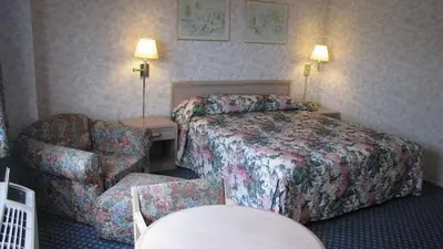 a hotel room with a bed and a chair at Nisei Inn in Gardena